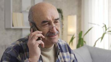 Senior old man talking on the phone is getting angry and grumpy. The old man, who is angry with the person on the phone, hangs up the phone. Irritability and dementia. video