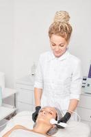 cosmetóloga hace rf levantamiento para rejuvenecimiento mujer rostro, anti envejecimiento cosmético procedimiento foto