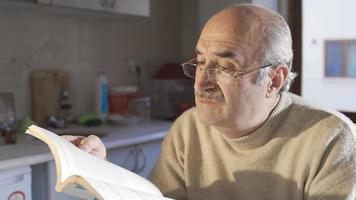 colto vecchio pensionato uomo studiando, apprendimento e apprendimento a casa. il vecchio uomo legge libri nel il suo la pensione, utile conoscenza e è Aperto per apprendimento. video