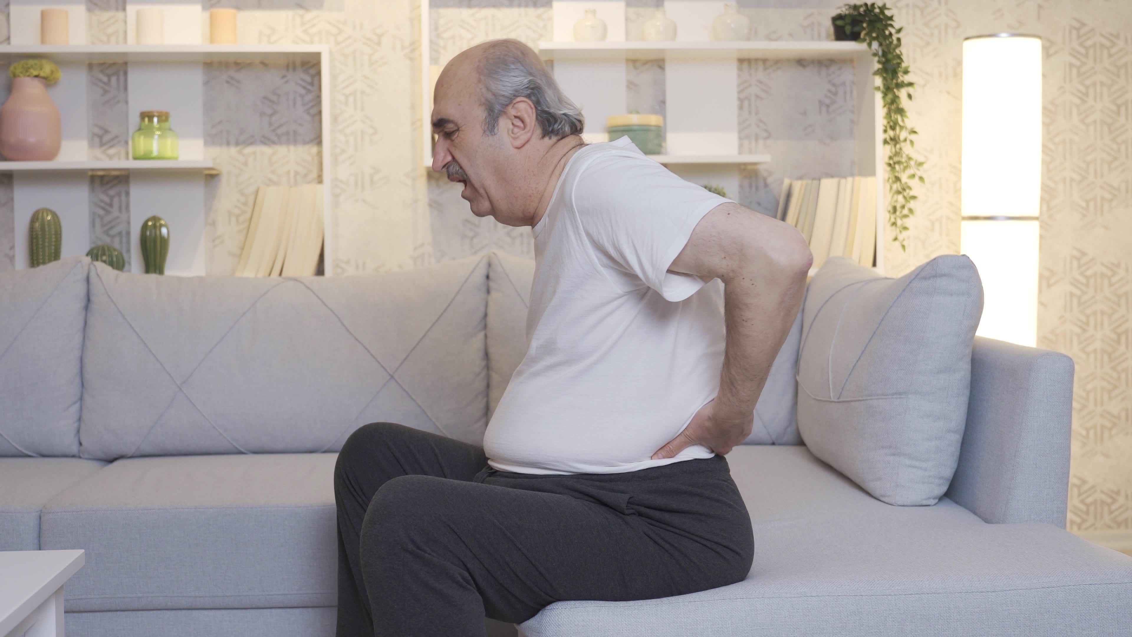 The old man's back hurts. Lumbar hernia and joint pain. Old man with