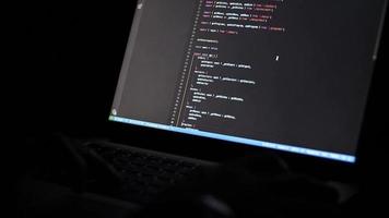 persona de libre dedicación programación a noche en ordenador portátil con borroso pantalla de cerca. manos en teclado video