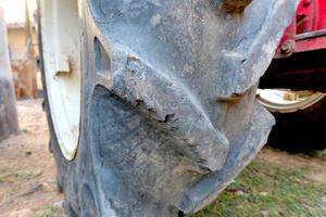 Red tractor with old wheel tire background photo