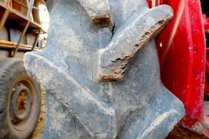 Red tractor with old wheel tire background photo