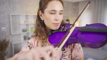 Musician woman performing her art at home. Young musician woman playing her violin at home, composing songs, producing. video