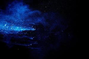 Blue  color powder explosion cloud on black background. Closeup of Blue  dust particles splash. photo