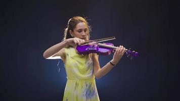 joven hermosa músico mujer jugando el violín. joven mujer jugando violín en negro fondo, suspenso, drama o emocional notas video