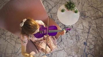 avvicinamento di musicista donna giocando violino a casa. comporre, giocando musica. giovane musicista donna giocando sua violino a casa, comporre canzoni, produrre. video