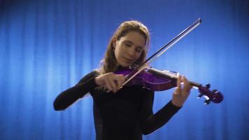 femmina musicista giocando violino sorridente e contento. musica lirica cantante. musica insegnante. il violinista donna giochi il violino su palcoscenico e prende perso tra il melodie. musicale talento. video