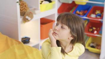 linda pequeño niña es considerado. imaginar. pensativo pequeño niña soñando en su cabeza, pensando de un nuevo idea, mirando para un solución, molesto a recordar. video