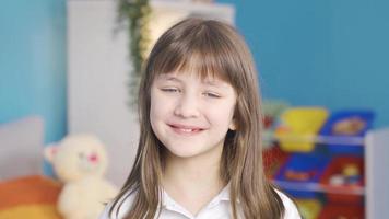 linda pequeño niña es sonriente. niña niño. hermosa pequeño niña con rubia pelo y azul ojos sonriente, energético positivo. video