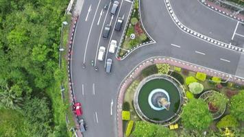 drone baleado na rua com cruzamentos e carros. tráfego de carros na estrada e as pessoas atravessam a rua durante o dia video