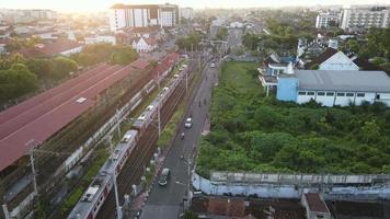 Aerial view of passenger train crossing rail bridge in near Tugu Station. video