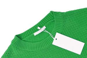 White blank rectangular clothing tag on green knitted sweater isolated on white background photo