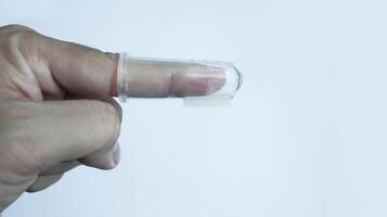 A hand wearing baby tooth brush or infant tooth brush, helping the first teeth clean isolated on white some negative space. photo