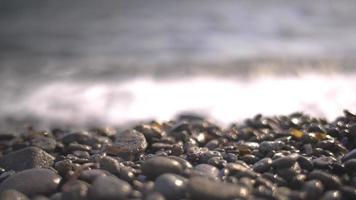 un' vulcanico roccia spiaggia con estremo bokeh e simpatico su di messa a fuoco le zone video