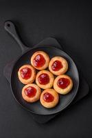 Delicious fresh cottage cheesecakes with raisins and vanilla on a black ceramic plate photo