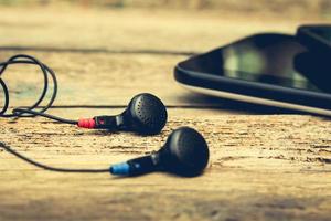 auriculares, tableta en antiguo madera antecedentes. tonificado imagen. foto