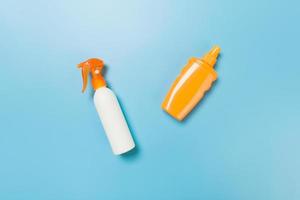 flat lay concept of summer travel vacation. Sunscreen bottle mock up on blue background top view with copy space photo