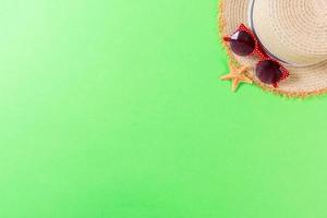 summer holiday beach background with accessories on green table, top view with copy space. vacation concept photo