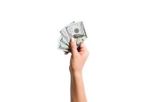 Female hand giving a bundle of dollar bills on white isolated background. Top view of power and wealth concept photo
