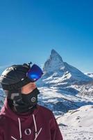 Young snowboarder spending winter holidays in Zermatt, near the famous Matterhorn peak. Male posing in Swiss Alps for the snowboarding season. photo