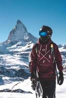 Young snowboarder spending winter holidays in Zermatt, near the famous Matterhorn peak. Male posing in Swiss Alps for the snowboarding season. photo