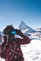 Young snowboarder spending winter holidays in Zermatt, near the famous Matterhorn peak. Male posing in Swiss Alps for the snowboarding season. photo