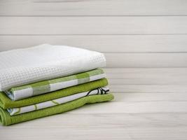 un pila de pulcramente doblada toallas en de madera antecedentes. producción de natural textil fibras.orgánicas producto. natural paño foto