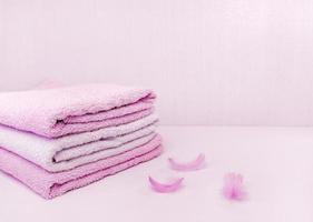A stack of neatly folded pink bath towels, soft as a feather. Space for text photo