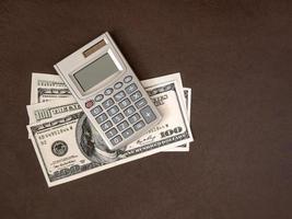 Calculator, coins and banknotes on a dark background. The idea of business, Finance concept and saving money and time photo