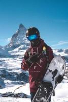 Young snowboarder spending winter holidays in Zermatt, near the famous Matterhorn peak. Male posing in Swiss Alps for the snowboarding season. photo