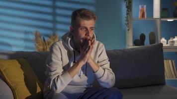 ledsen man Sammanträde på Hem, familj problem, relation problem, påfrestning, depression begrepp. omtänksam deprimerad ung man är olycklig på Hem ensam och har psykologisk problem. till vara besviken. video