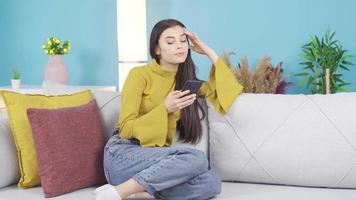 triste preoccupato giovane donna guardare a Telefono, confuso, pensieroso. triste, frustrato solitario giovane donna pensa di dolore. essere imbrogliato Su, essere abbandonato, cattivo notizia. video