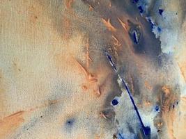 A blue and orange painting with a white background and blue paint. photo