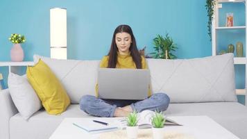 linda y contento hermosa joven hembra estudiante mirando a ordenador portátil a hogar, estudiando, enviando correo, mecanografía texto. joven niña a hogar solo mirando a el computadora portátil, estudiando. video