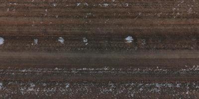top view of surface of gravel road made of small stones and sand with traces of car tires photo