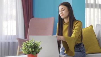 Beautiful young entrepreneur woman working from home happily working from laptop. Happy young entrepreneur young woman working from home, taking and placing orders, viewing catalogs, video