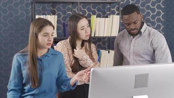 Multiethnic people working together in office, working in team. Multiethnic group working as a team on a project. Asian woman, European woman and African man. video