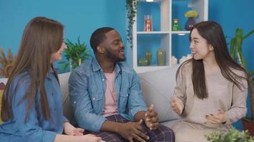 Multiethnic college students chatting at home. University students of Asian women, black men and European women chatting at home. video