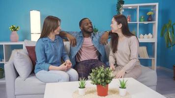 Young people of different races chatting and happy at home.  Black teen, asian teen and european teen chatting at home. They are fun and happy. video