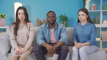 Multiethnic young people looking at camera with dull expression. European young woman, Asian young woman and African young man looking at camera with dullness. video