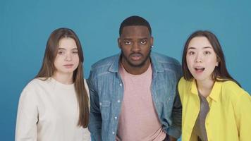 Multiethnic people, black, Asian and European youth are stunned, surprised and fascinated. Asian teenage girl, black man and european teenage girl looking at camera surprised, wow. video