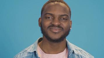 Happy positive young black man smiling, looking at camera. Happy and handsome black male model smiling, looking at camera. video