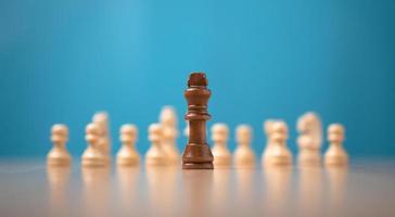 Rey marrón ajedrez en pie en frente de blanco ajedrez, concepto de un nuevo puesta en marcha debe tener valor y desafío en el competencia, liderazgo y negocio visión para un ganar en negocio juegos foto