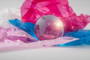 The crystal globe on plastic bag. Plastic waste overflows the world. Global Warming and Climate Change concept. photo