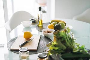 Fresco verde sano frutas y vegetales en mesa mientras Cocinando en cocina a hogar foto