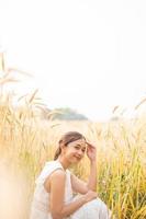 Young Asian women  in white dresses sitting in the Barley rice field photo