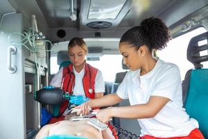 Paramedic using defibrillator AED  in conducting a basic cardiopulmonary resuscitation. Emergency Care Assistant Putting Silicone Manual Resuscitators in an Ambulance. photo