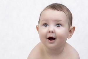 Surprised child's face. Portrait of a newborn baby with a funny shocked expression photo