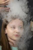 The child is a participant in scientific experiments. Girl in liquid nitrogen smoke. photo